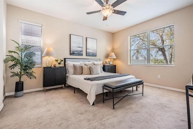 carpeted bedroom featuring baseboards and a ceiling fan