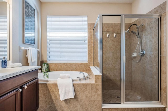 bathroom with a healthy amount of sunlight, a shower stall, a bath, and vanity