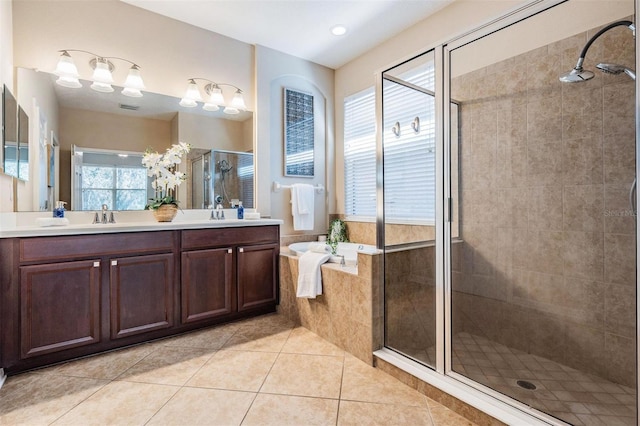 full bathroom featuring double vanity, a stall shower, a bath, tile patterned flooring, and a sink