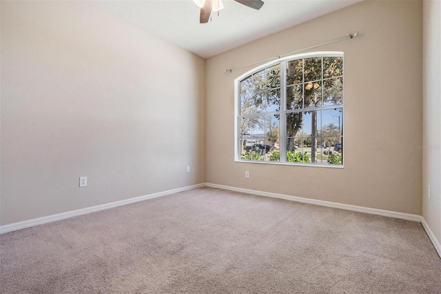 spare room featuring ceiling fan, carpet, and baseboards