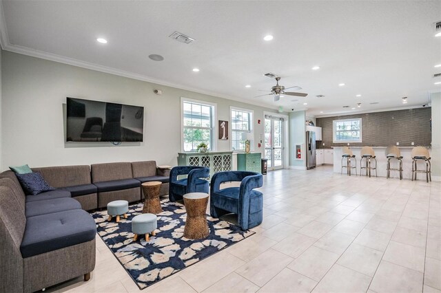 living area with a wealth of natural light, visible vents, crown molding, and recessed lighting