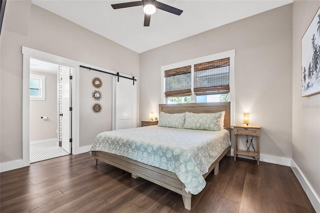 bedroom with multiple windows, dark wood finished floors, and a barn door