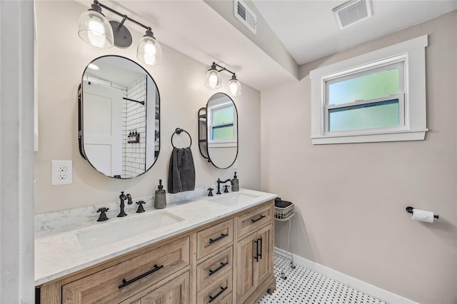 bathroom featuring visible vents, a sink, and double vanity