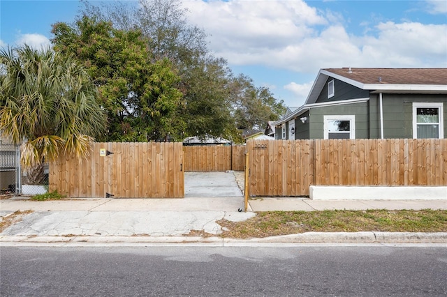 view of home's exterior with a fenced front yard and a gate