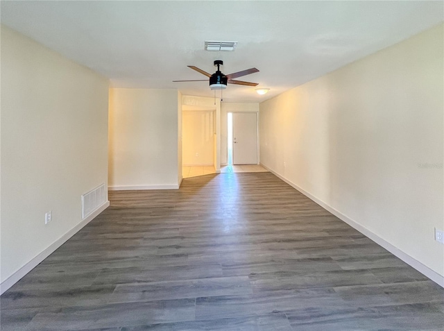 spare room with a ceiling fan, baseboards, visible vents, and wood finished floors