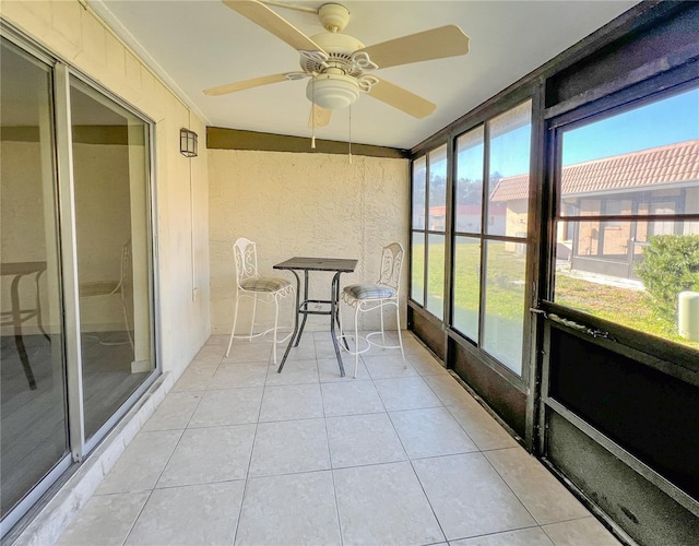 unfurnished sunroom featuring a ceiling fan