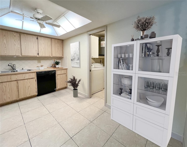 kitchen featuring black dishwasher, light tile patterned floors, light brown cabinetry, a sink, and separate washer and dryer