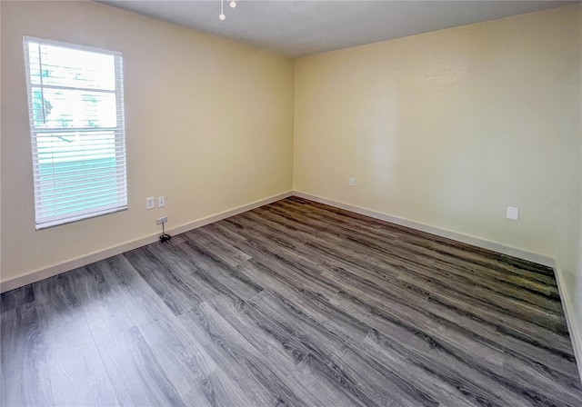 empty room with dark wood-style floors and baseboards