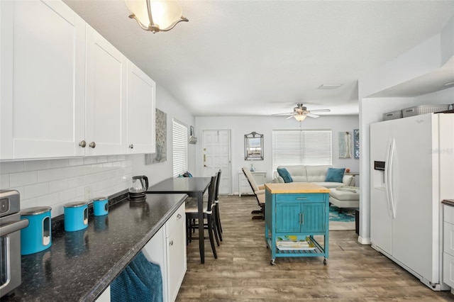 kitchen with decorative backsplash, white cabinetry, white refrigerator with ice dispenser, and wood finished floors