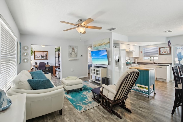 living room featuring wood finished floors, visible vents, and ceiling fan