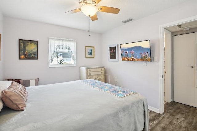 bedroom with a ceiling fan, wood finished floors, visible vents, and baseboards