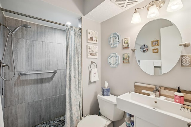 bathroom with visible vents, a shower stall, toilet, and a sink