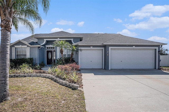 view of front facade with an attached garage, roof with shingles, concrete driveway, and stucco siding