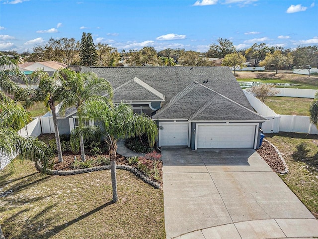 view of front of house featuring a garage, concrete driveway, fence, and a shingled roof