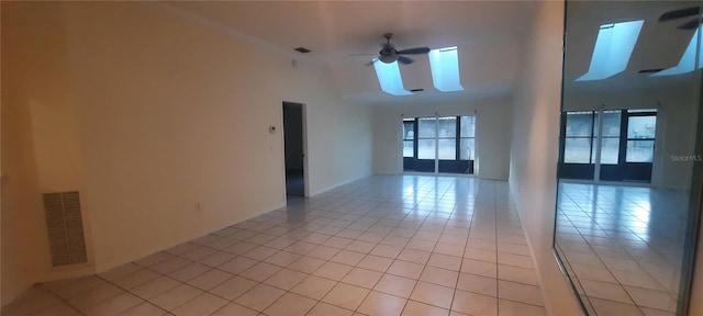 empty room with light tile patterned floors, ceiling fan, and visible vents