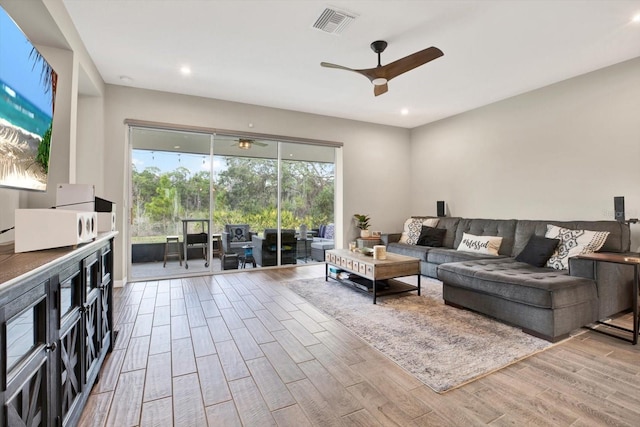 living area with visible vents, ceiling fan, and wood finished floors