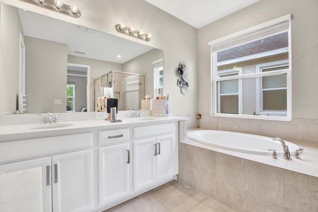 full bathroom with double vanity, a stall shower, a sink, and a bath