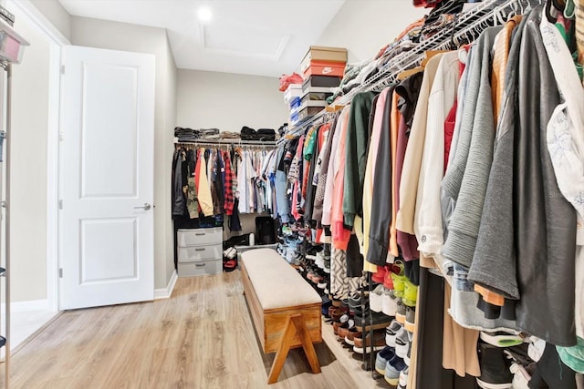 spacious closet with wood finished floors and attic access