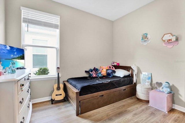 bedroom with light wood finished floors and baseboards