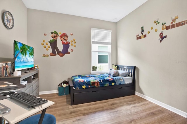 bedroom with wood finished floors and baseboards