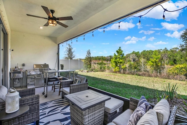 view of patio with an outdoor hangout area, a grill, a ceiling fan, fence, and exterior kitchen