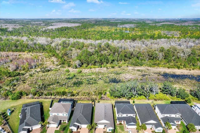 drone / aerial view with a wooded view and a residential view