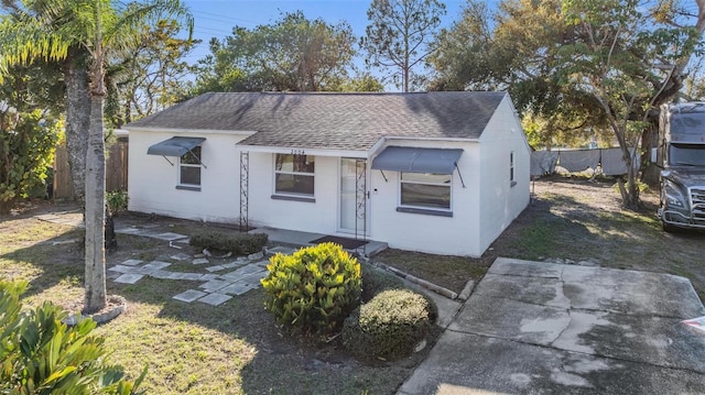 view of front of property with a shingled roof and fence