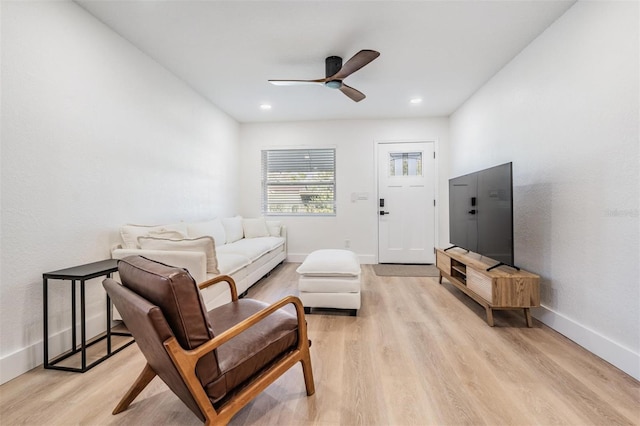 living area featuring baseboards, recessed lighting, a ceiling fan, and light wood-style floors