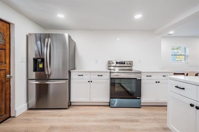 kitchen featuring light wood finished floors, white cabinets, stainless steel appliances, light countertops, and recessed lighting