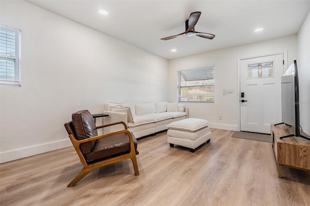 living room featuring light wood-style flooring, baseboards, ceiling fan, and recessed lighting