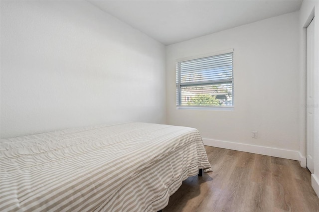 bedroom featuring baseboards and wood finished floors