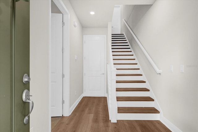 staircase featuring recessed lighting, baseboards, and wood finished floors