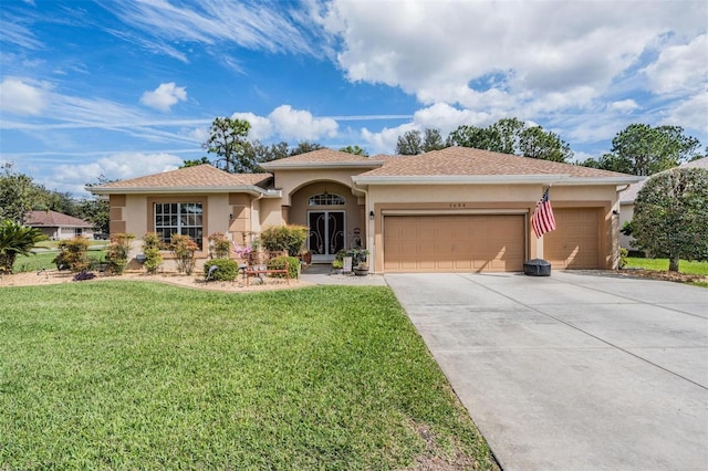 mediterranean / spanish-style home featuring an attached garage, driveway, a front lawn, and stucco siding