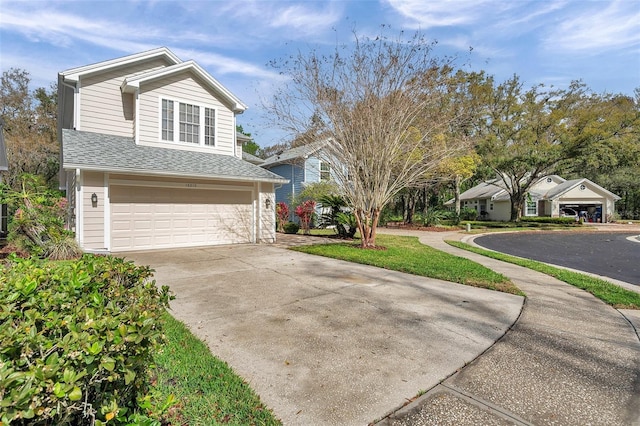 view of front of home with a garage, concrete driveway, and roof with shingles