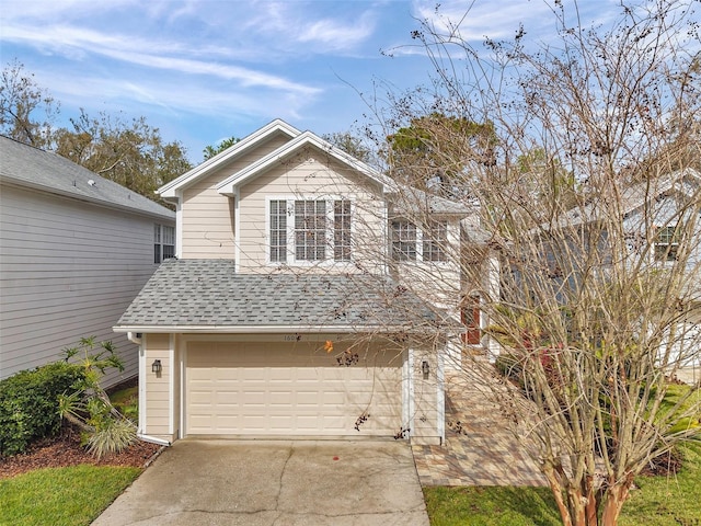 traditional home with driveway, a shingled roof, and an attached garage