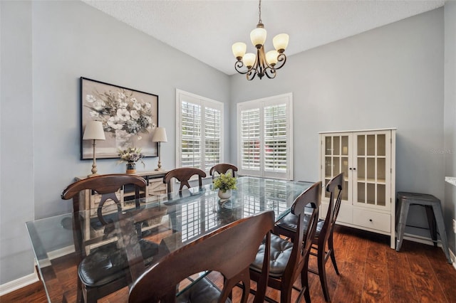 dining space with baseboards, dark wood finished floors, and a notable chandelier