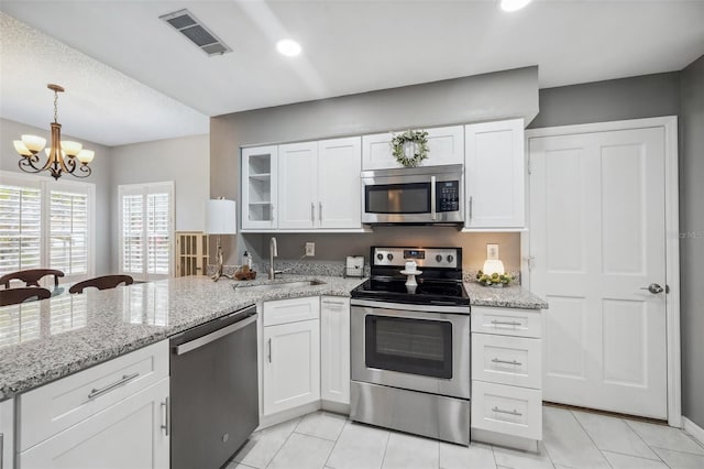 kitchen with stainless steel appliances, visible vents, and white cabinetry