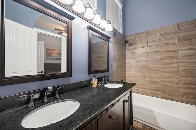 bathroom with double vanity, shower / bath combination, a ceiling fan, and a sink