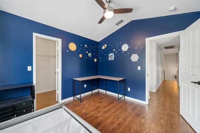 unfurnished bedroom with lofted ceiling, baseboards, visible vents, and wood finished floors