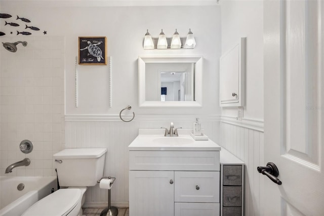 full bathroom with shower / washtub combination, wainscoting, vanity, and toilet