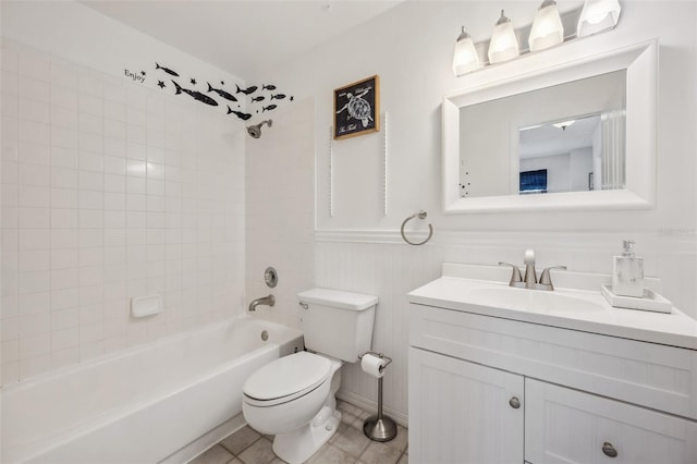 bathroom featuring toilet, wainscoting, vanity, shower / tub combination, and tile patterned flooring