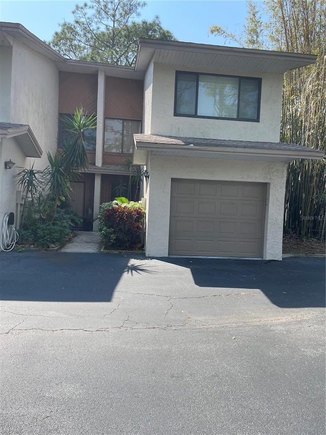 view of front of home featuring stucco siding, an attached garage, and aphalt driveway