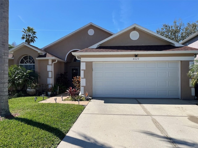 ranch-style house with concrete driveway, a front lawn, an attached garage, and stucco siding