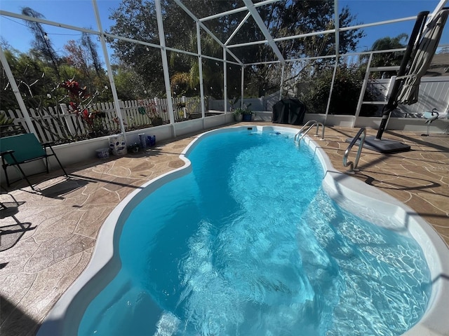 view of swimming pool with a lanai, a fenced backyard, and a patio