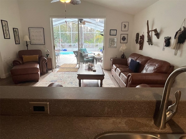 living room with lofted ceiling, a sunroom, and ceiling fan