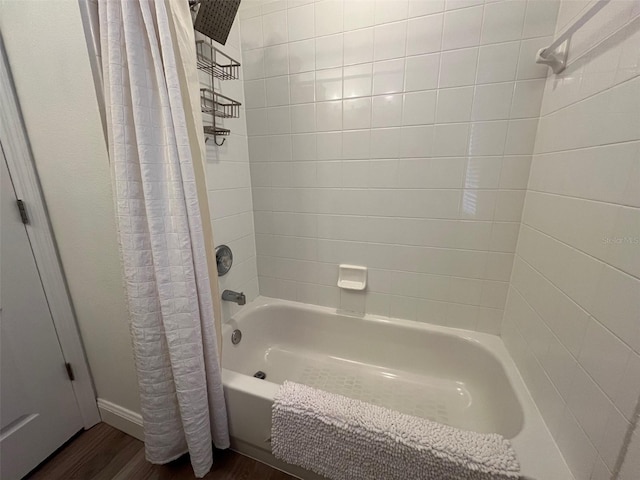 bathroom with shower / bath combo with shower curtain and wood finished floors