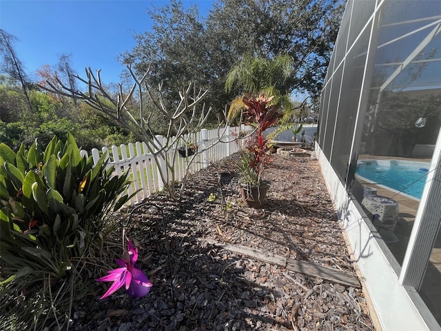 view of yard with glass enclosure, a fenced backyard, and a fenced in pool