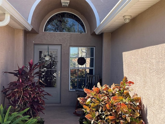 doorway to property featuring stucco siding