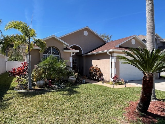 view of front of house featuring an attached garage, fence, concrete driveway, stucco siding, and a front lawn