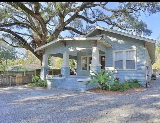 view of front of home with covered porch and fence